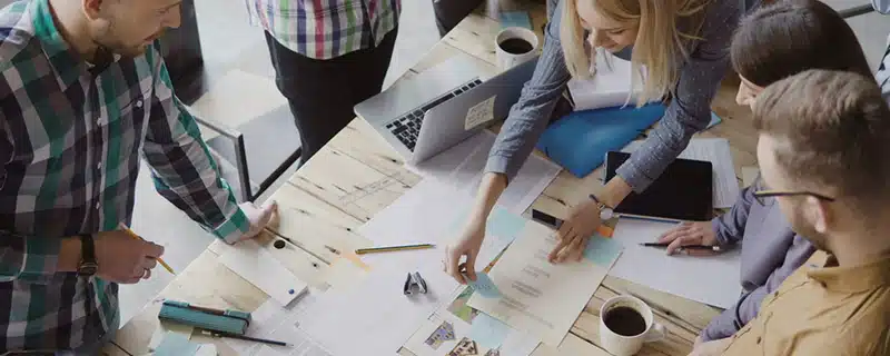 Menschen am Tisch mit Fotos und Statistiken - Content Marketing ist König
